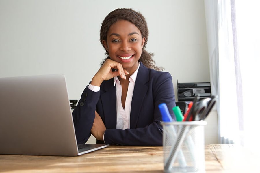 young-black-businesswoman-sitting-at-office-desk-SQZDS5W.jpg